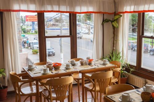 a wooden table and chairs in a room with a window at Hotel Bahia Nueva in Puerto Madryn