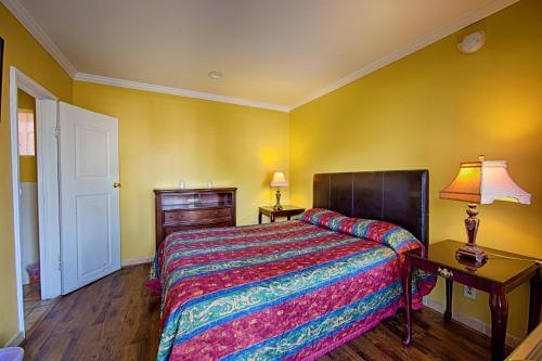 ein Schlafzimmer mit einem Bett, einem Tisch und einer Lampe in der Unterkunft Central Inn Motel in Los Angeles