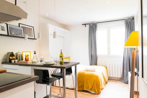 - une cuisine avec une table et un lit dans une chambre dans l'établissement Unsejouranantes - Le Studio Fouré, à Nantes