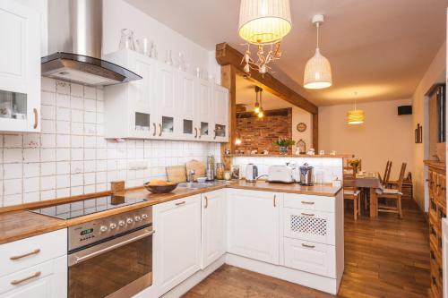 a kitchen with white cabinets and a counter top at Podlesice 38 in Kroczyce