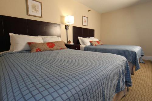 a hotel room with two beds with blue and white sheets at Harrison Hall Hotel in Ocean City
