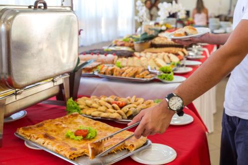 een buffet lijn met borden eten op tafel bij Porto Cálem Praia Hotel in Porto Seguro