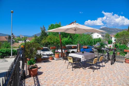 patio con ombrellone, tavolo e sedie di D&D Apartments a Tivat