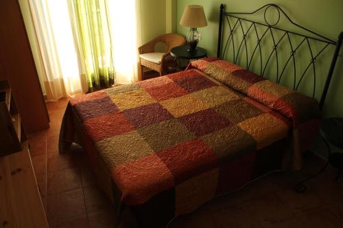 a bedroom with a bed with a quilt on it at Hostal Zaguan in Talaveruela