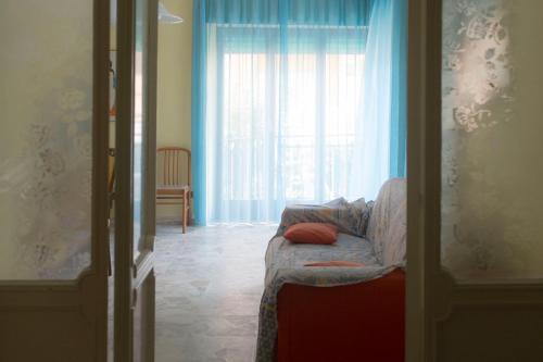 een woonkamer met een bank en een raam bij Casa Leda in Sperlonga