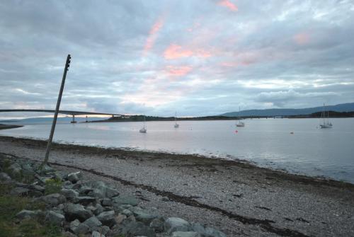 a group of boats in the water with a bridge at Saucy Mary's Hostel in Kyleakin