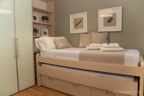 a small bedroom with a bed and shelves at Alcam Bailen Garden in Barcelona