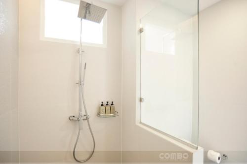 a bathroom with a shower with a glass door at Combo Beach Hotel Samui in Chaweng