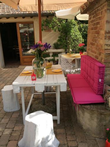 a white table with a red chair and a vase of flowers at Giannetti Bed & Breakfast in Poggio alle Mura