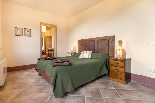 1 dormitorio con cama verde y tocador de madera en Poggio La Croce, en Scarlino