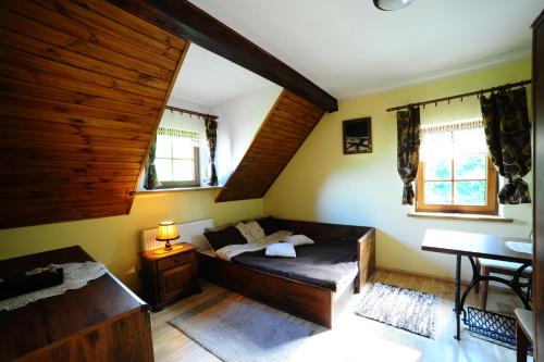 1 dormitorio con cama, mesa y ventanas en Przystań Jaskółka en Ruciane-Nida