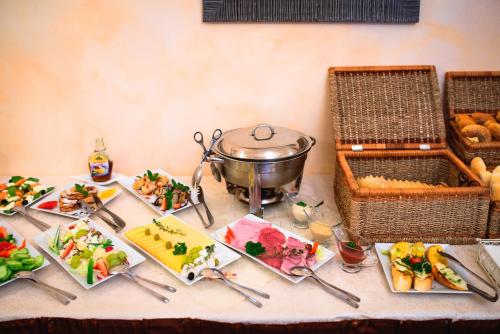 a table with plates of food and a pot on it at Hotel Kaskada in Poprad