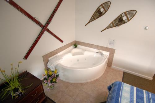 a bathroom with a bath tub in a room at Colonial Motel in North Conway