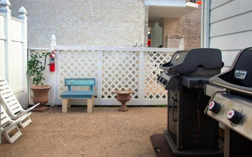 a backyard with a grill and a blue chair at Horizon Motor Inn-Beach Block & Close to Morey's Piers in North Wildwood