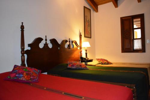 a bedroom with two beds and a red mattress at Hotel Candelaria Antigua in Antigua Guatemala