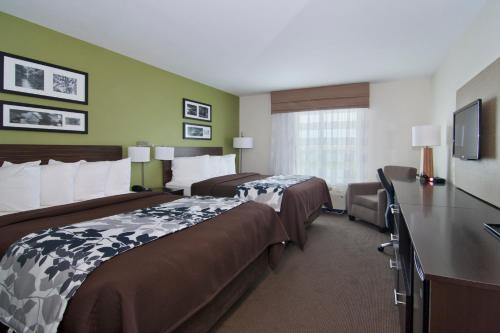 a hotel room with two beds and a desk at Sleep Inn & Suites Marshall in Marshall
