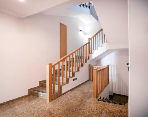 a staircase in a house with white walls and wooden railings at Pensión O Códice by Moradas Nieto in Santiago de Compostela