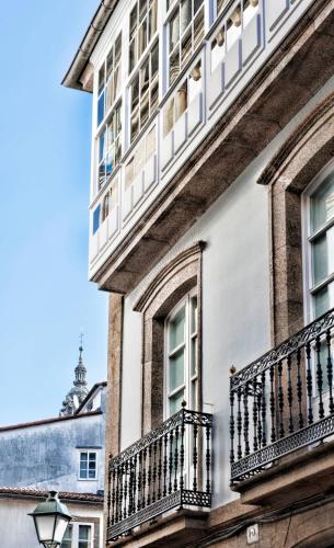 a building with balconies on the side of it at Pensión O Códice by Moradas Nieto in Santiago de Compostela