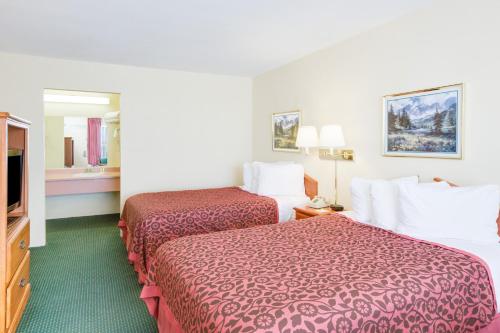 a hotel room with two beds and a flat screen tv at Days Inn by Wyndham Newport in Newport