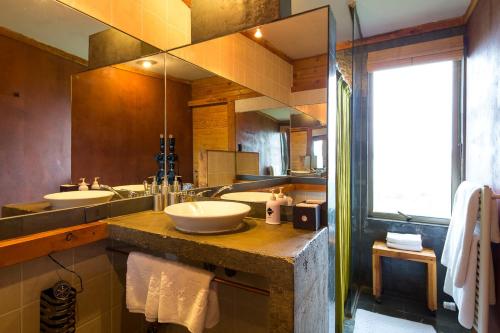 a bathroom with two sinks and a large mirror at Hotel Altiplanico Puerto Natales in Puerto Natales