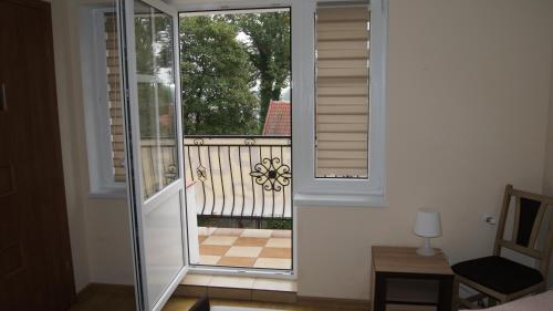 a glass door leading to a balcony with a railing at Zajazd Nadmorski in Stegna
