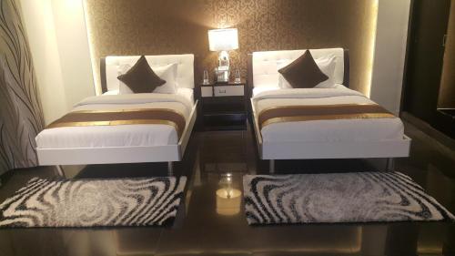 two beds in a room with mirrored floors at Nelover Qurtubah-Serviced apartments in Riyadh