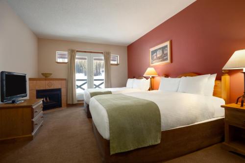 
a hotel room with a bed and a television at Coast Sundance Lodge in Sun Peaks

