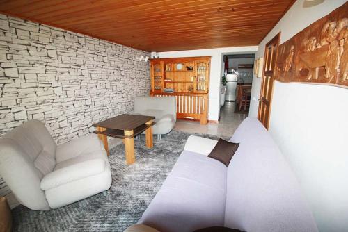 ポロニンにあるPoronin Apartamentの白いソファとレンガの壁が備わるリビングルーム