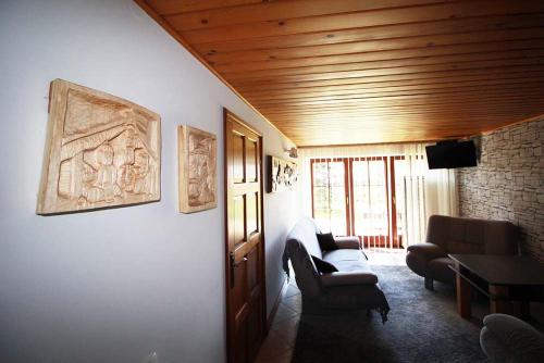 Una sala de estar con un sofá y sillas y una mesa. en Poronin Apartament, en Poronin