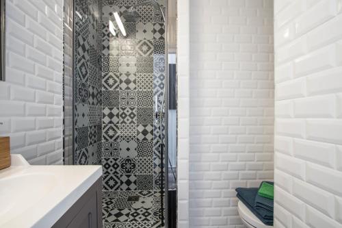 a shower in a bathroom with white subway tiles at Studio Couleur Soleil in Roquebrune-Cap-Martin