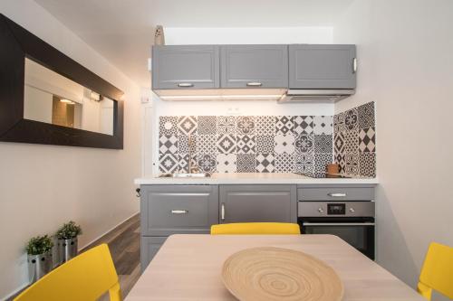 une cuisine avec une table et des chaises jaunes dans l'établissement Studio Couleur Soleil, à Roquebrune-Cap-Martin