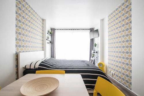 - une chambre avec un lit et une table avec des chaises jaunes dans l'établissement Studio Couleur Soleil, à Roquebrune-Cap-Martin