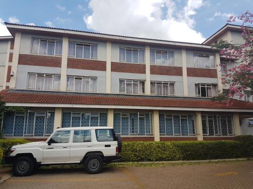 a white truck parked in front of a building at China Garden in Nairobi