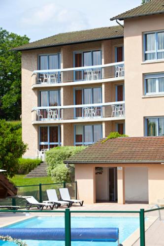 a hotel with a swimming pool in front of a building at Hôtel du Lac in Lacapelle-Viescamp