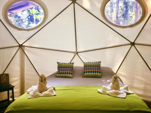 2 persone in asciugamani seduti su un letto in una yurta di Hotel Faith Glamping Dome Costa Rica a Manzanillo