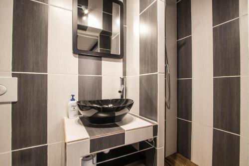 a bathroom with a sink and a mirror at Studio Mezzanine Bleu in Roquebrune-Cap-Martin