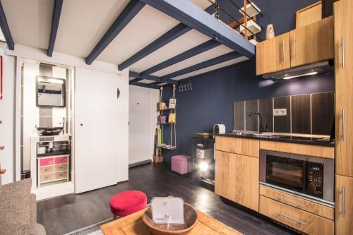 une grande cuisine avec des placards en bois et une table dans l'établissement Studio Mezzanine Bleu, à Roquebrune-Cap-Martin