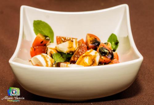 a white bowl of food on a table at Hotel & Restaurant Fleur de Lis in Concepción de Ataco