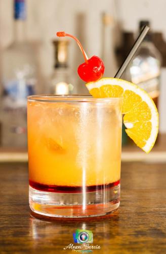 a glass of orange juice with a cherry on top at Hotel & Restaurant Fleur de Lis in Concepción de Ataco