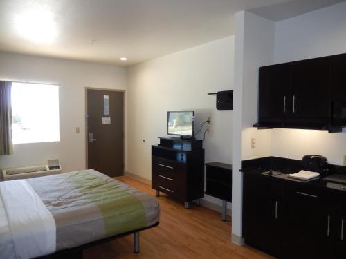 a hotel room with a bed and a television at Studio 6-Yukon, OK in Yukon
