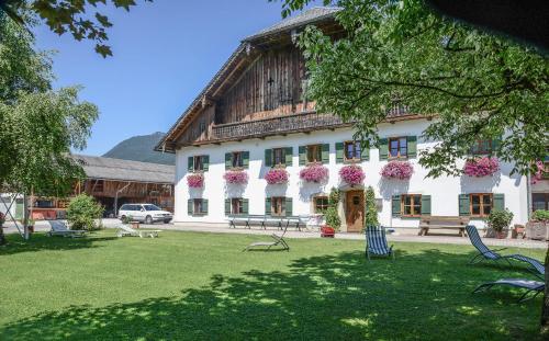 a large building with flowers on the front of it at Weinbachbauer - Urlaub am Bauernhof in St. Wolfgang