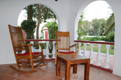 two rocking chairs and a table on a porch at Agroturismo Matxani Gran in Sant Climent