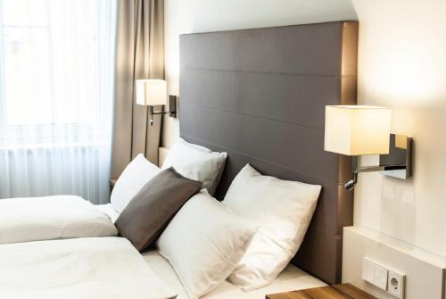 a bedroom with two beds with white pillows at Bayerischer Hof in Kitzingen