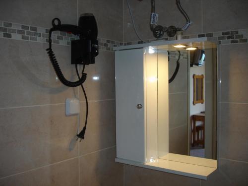 a bathroom with a shower with a mirror and a phone at Panorama in Perama