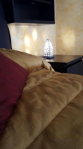 a bedroom with a bed with a lamp on a table at La Casa di Ninna Affittacamere in Ariano Irpino