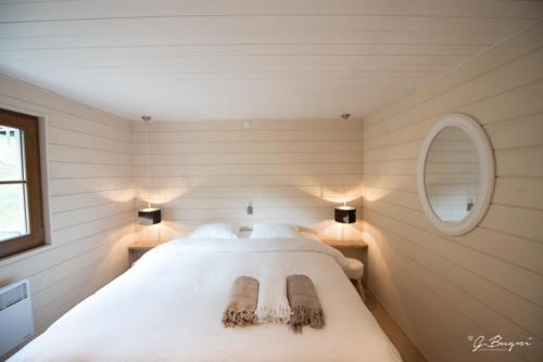 a bedroom with a large white bed in a room at Chalet Le Grand Cerf in Bullange