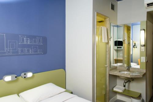 a room with a bed and a sink and a mirror at ibis budget Aracaju in Aracaju