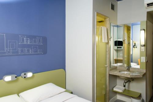 a room with a bed and a sink and a mirror at Celi Connect Hotel Orla Aracaju in Aracaju