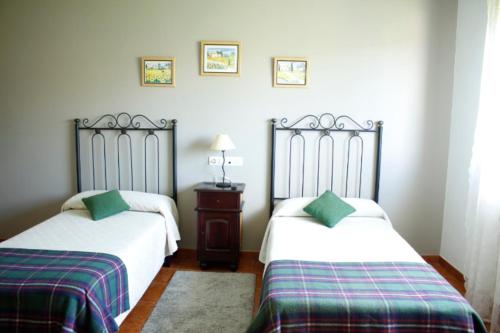 a bedroom with two beds and two lamps at Pensión Mosende in Porriño