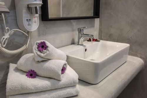 a bathroom with a sink and towels on a counter at Gianna Suites in Fira